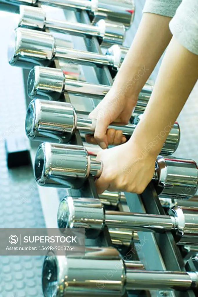 Woman picking up dumbbells