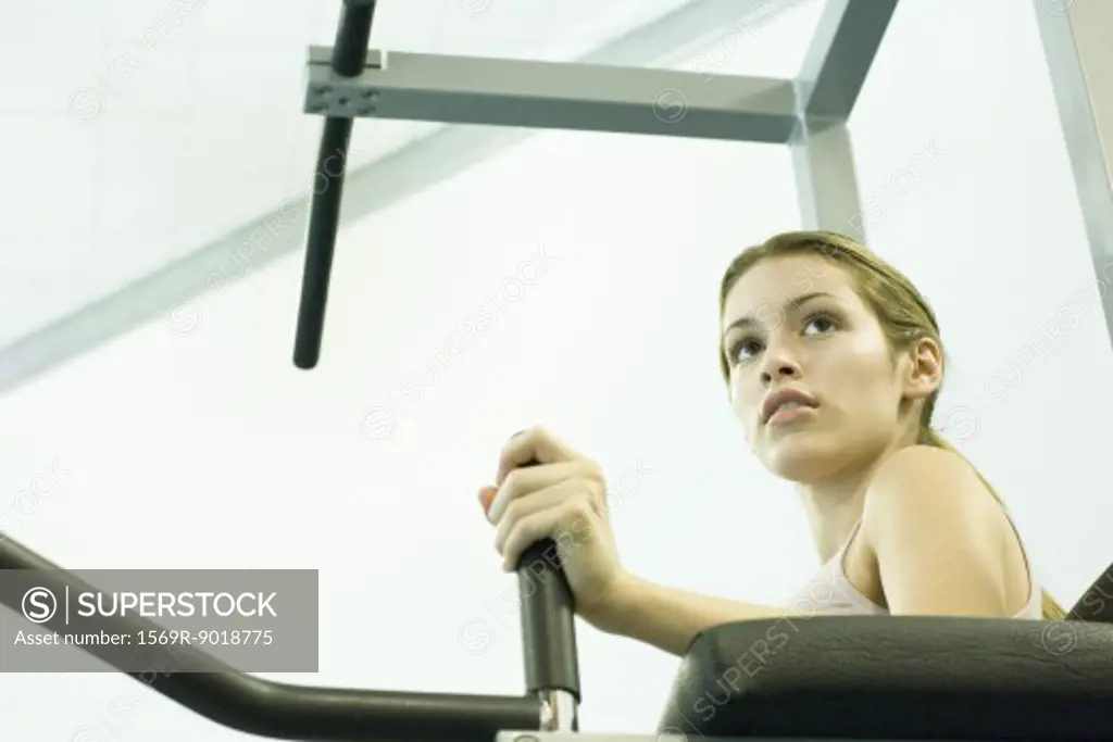 Woman using weight machine