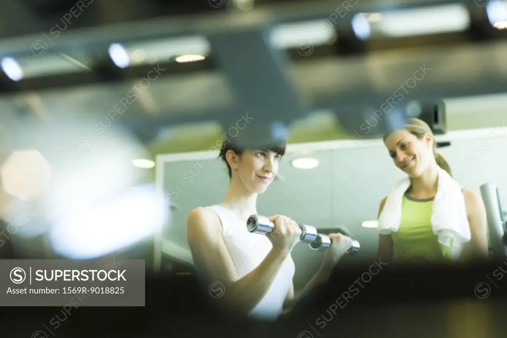Two women working out in weight room
