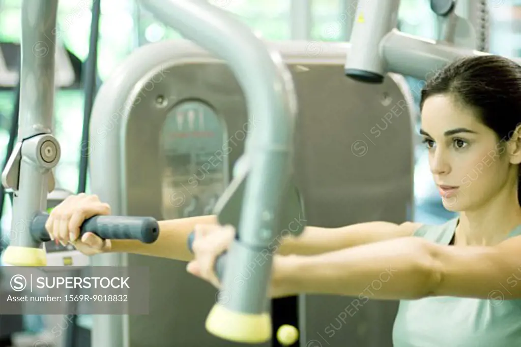 Woman working out with weight machine