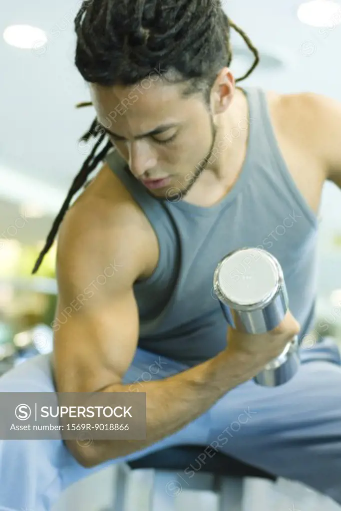 Man working biceps with dumbbell