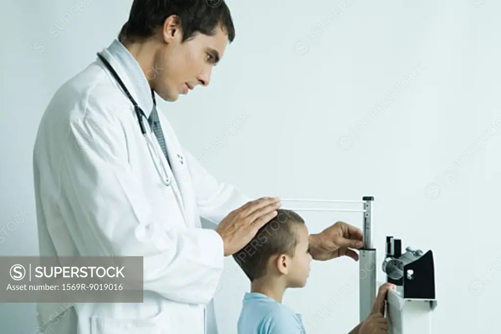 Doctor measuring boy during check-up