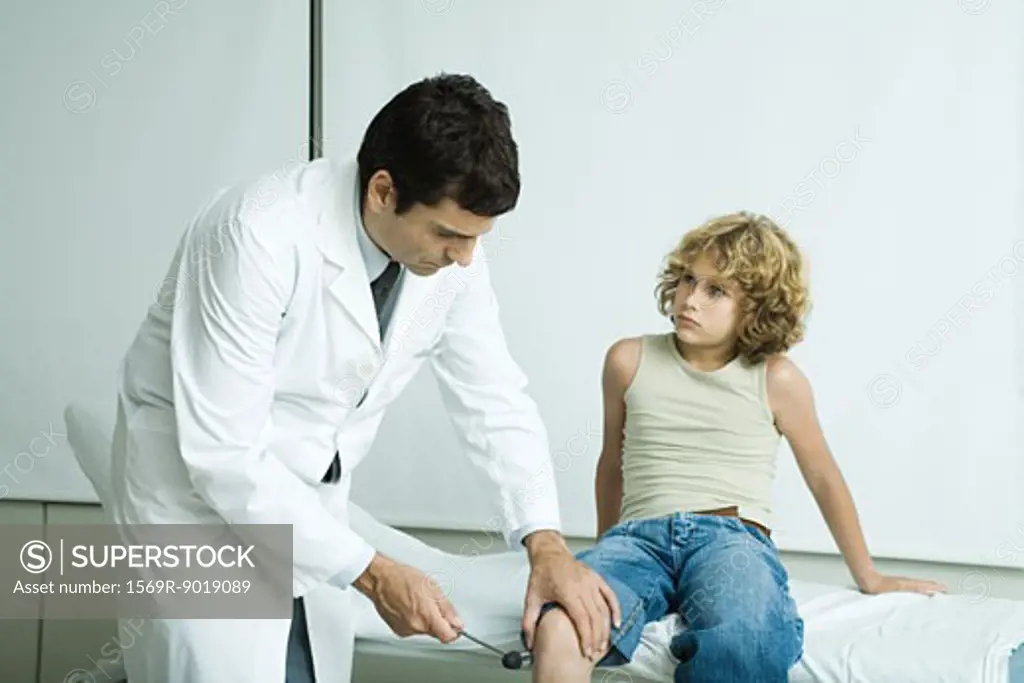 Doctor checking boy's reflexes