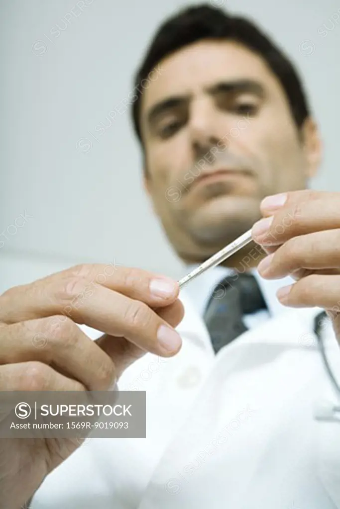 Doctor holding thermometer, low angle view