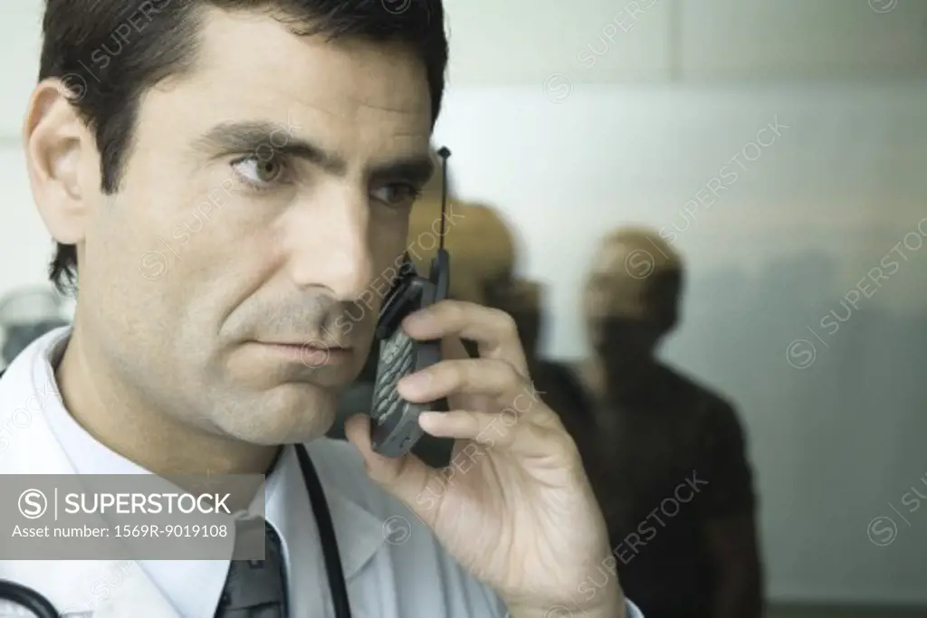 Doctor using cell phone, looking away
