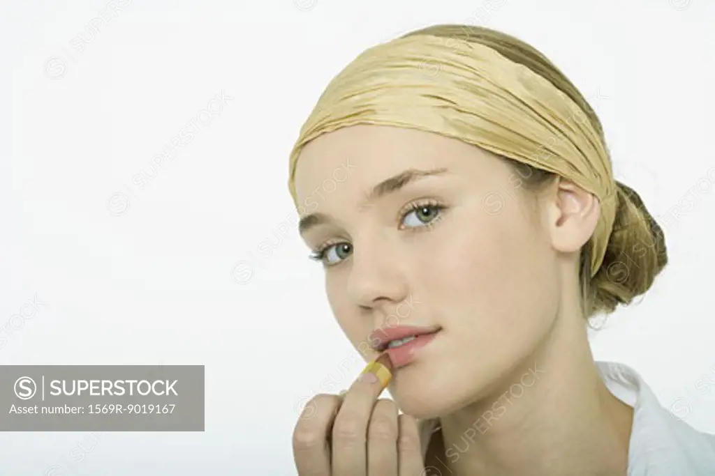 Teenage girl applying lipstick