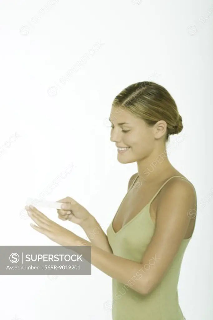 Young woman filing fingernails