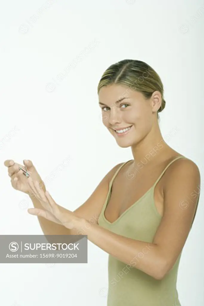 Young woman clipping fingernails