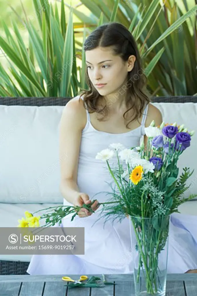 Young woman making fresh flower arrangement