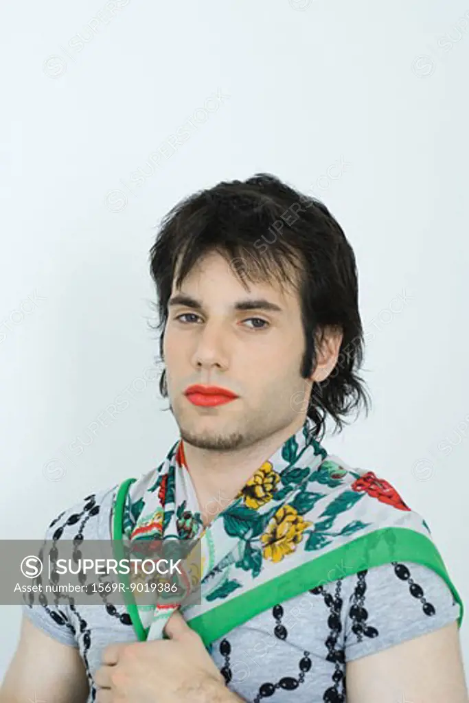 Young man wearing lipstick and scarf around neck, portrait