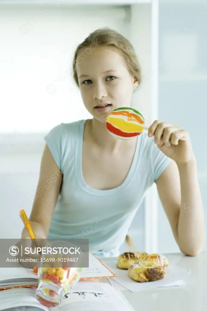 Girl eating sweets and doing homework