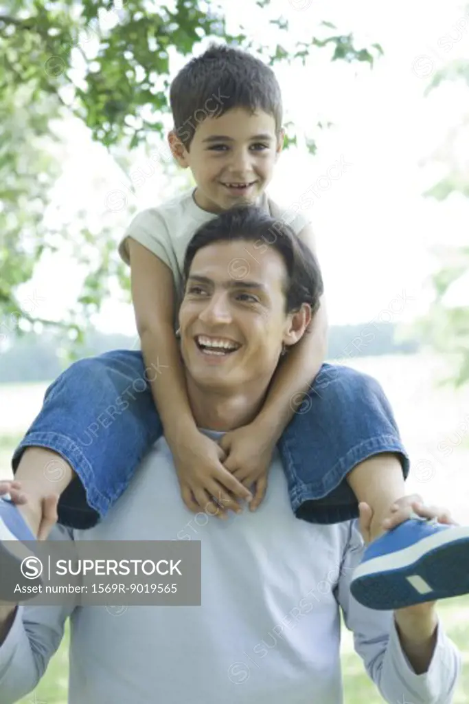 Boy and father, boy riding on man's shoulders