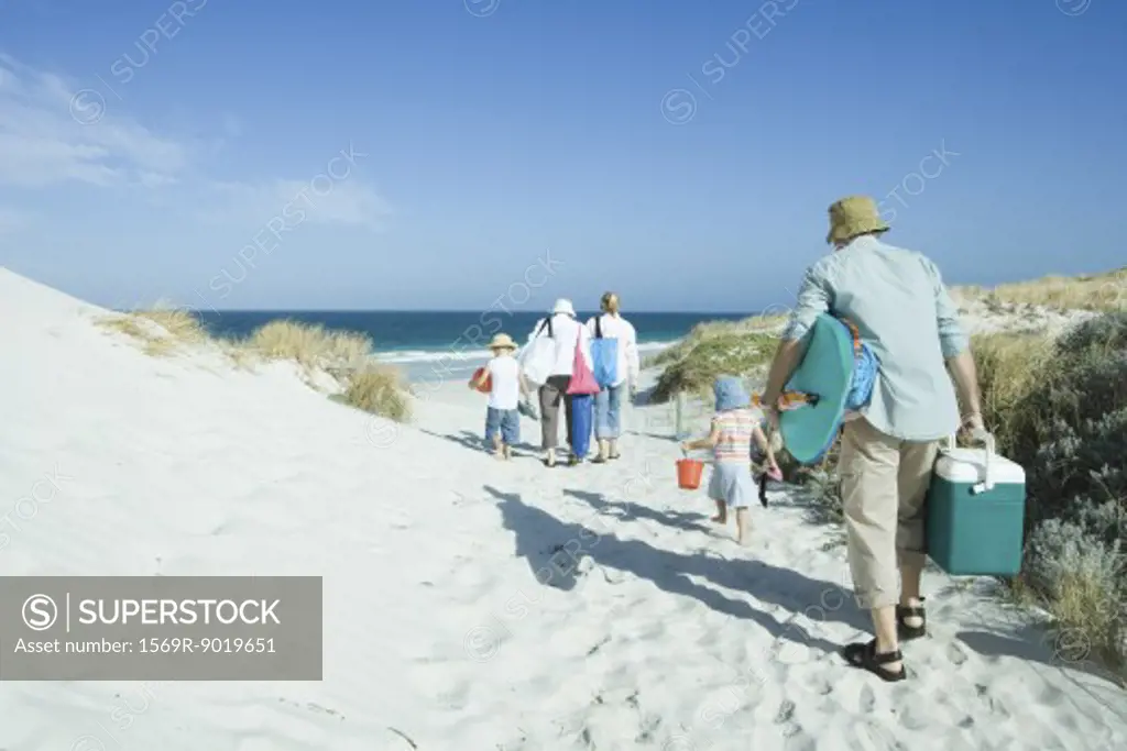 Family walking through dunes to beach