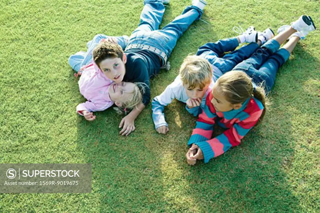 Children lying on grass together