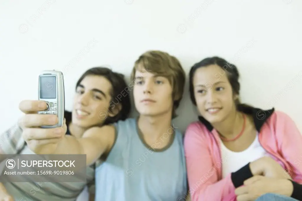 Three teen friends taking self portrait with cell phone