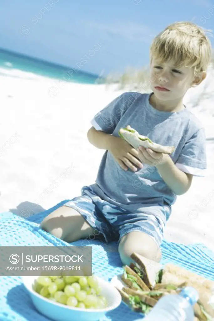 Boy eating on beach