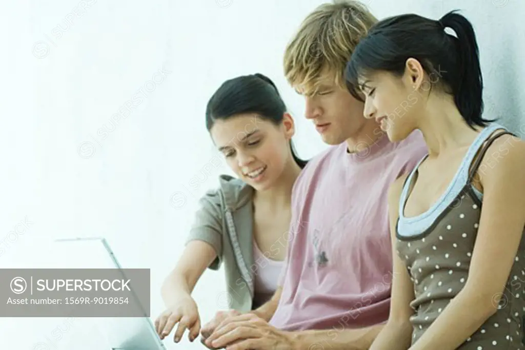 Young friends using laptop together