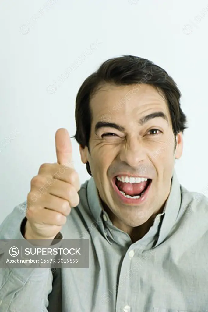 Man giving thumbs up sign, winking, portrait