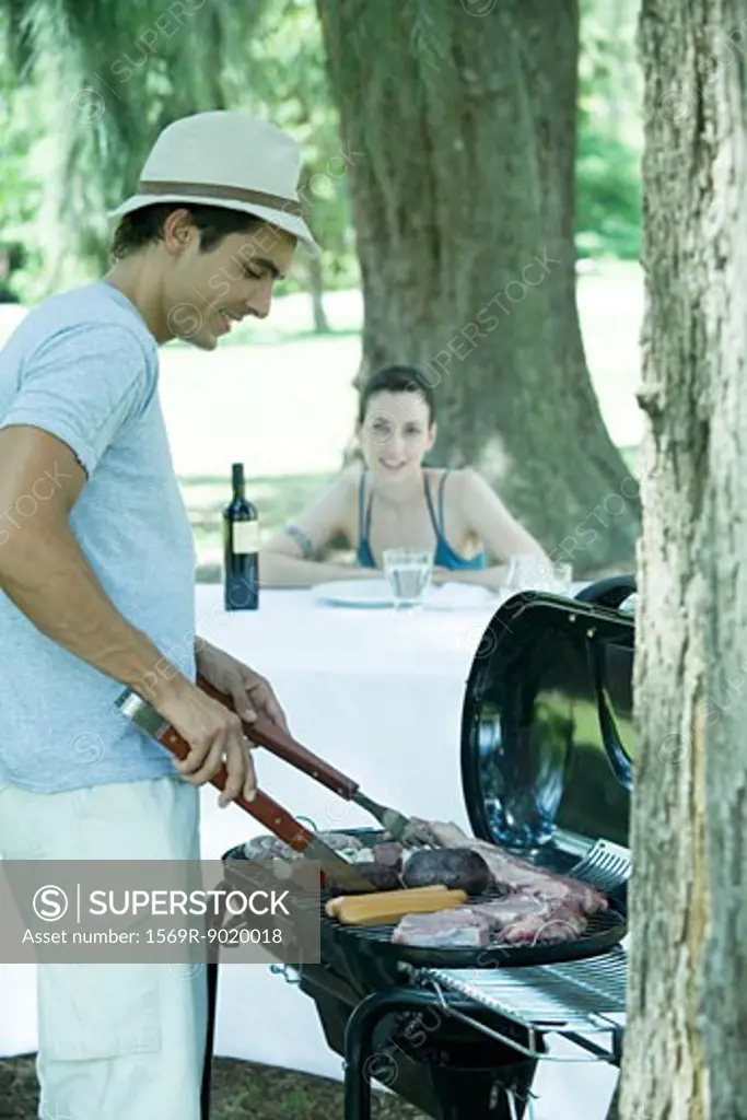 Man grilling meat on barbecue