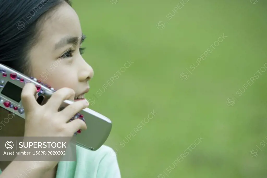 Girl using cell phone, side view, close-up