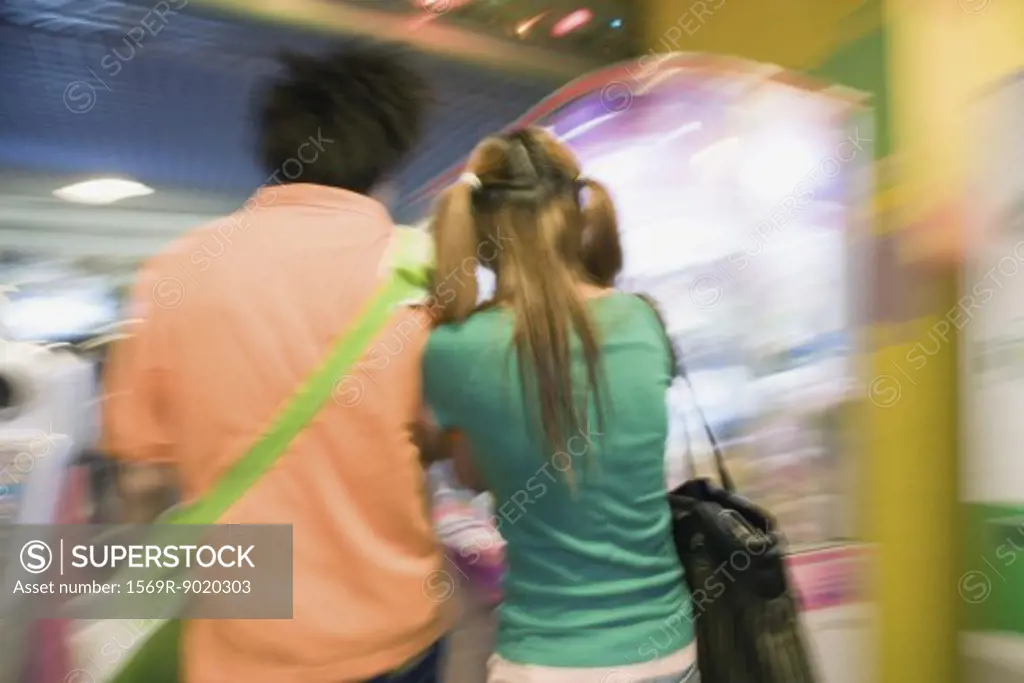 Teenage couple walking in video game arcade