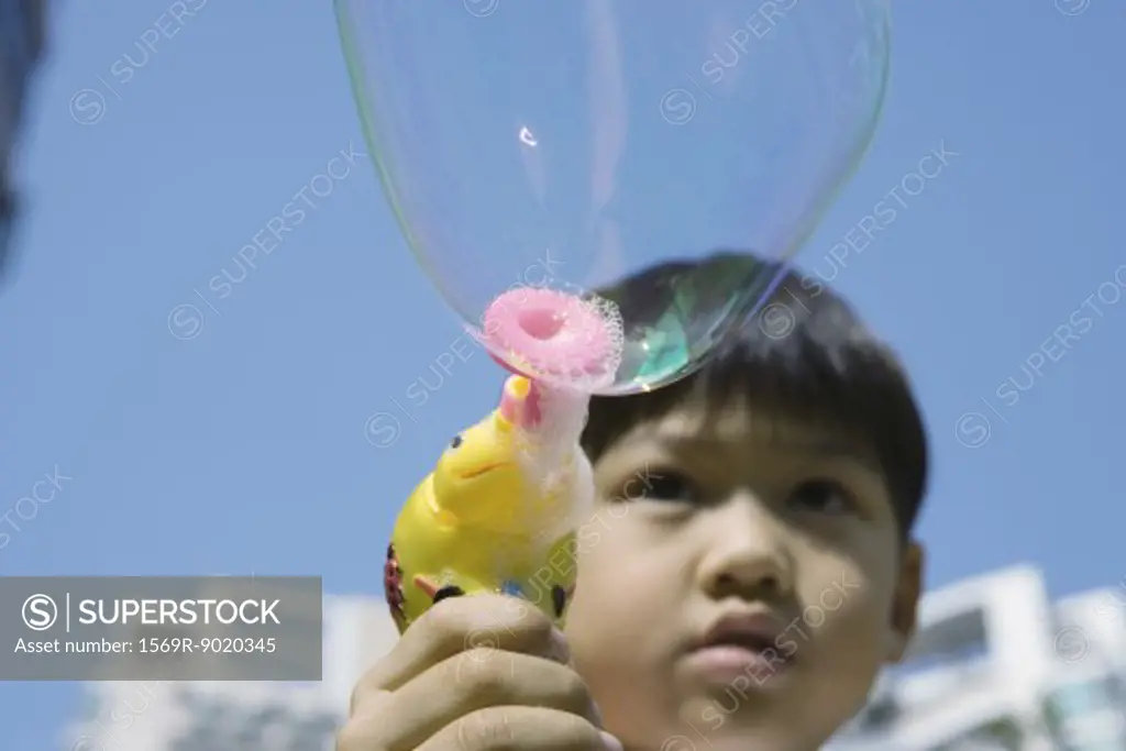 Boy making bubbles with bubble wand
