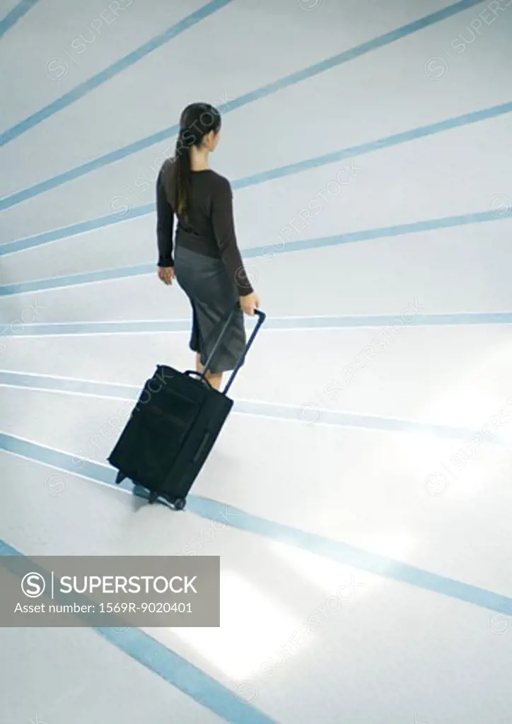 Woman walking with suitcase, full length, high angle view