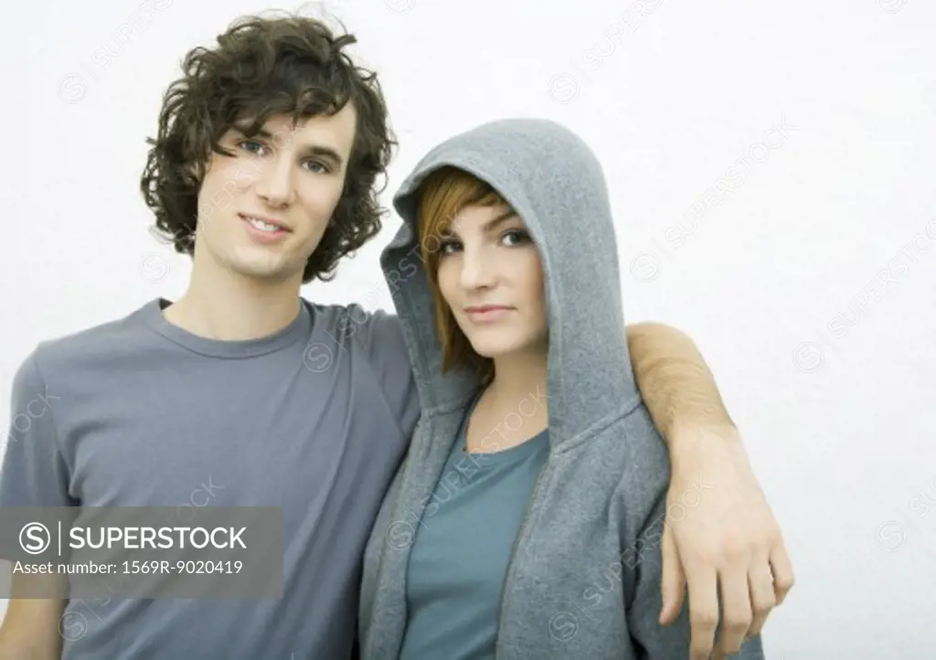 Young couple, man with arm around woman's shoulders, portrait