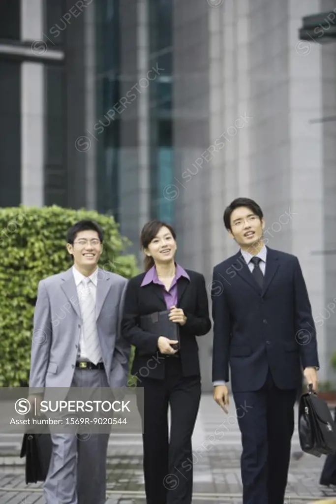 Three young executives walking side by side