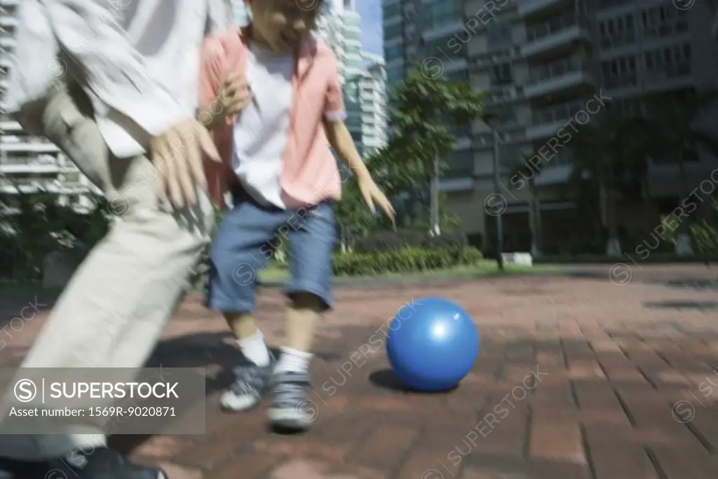 Father and son playing ball, blurred motion