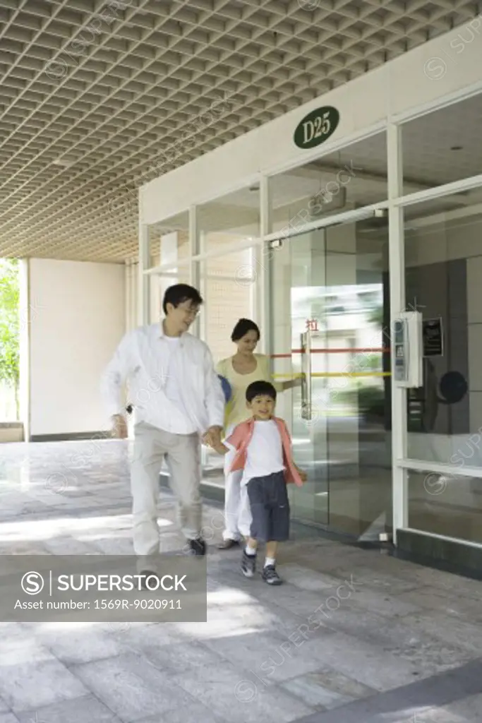 Family exiting apartment building lobby