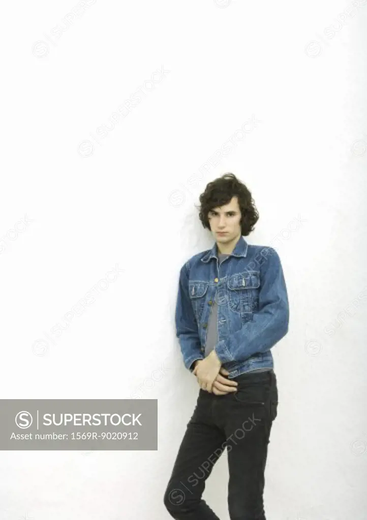 Young man leaning against wall, portrait