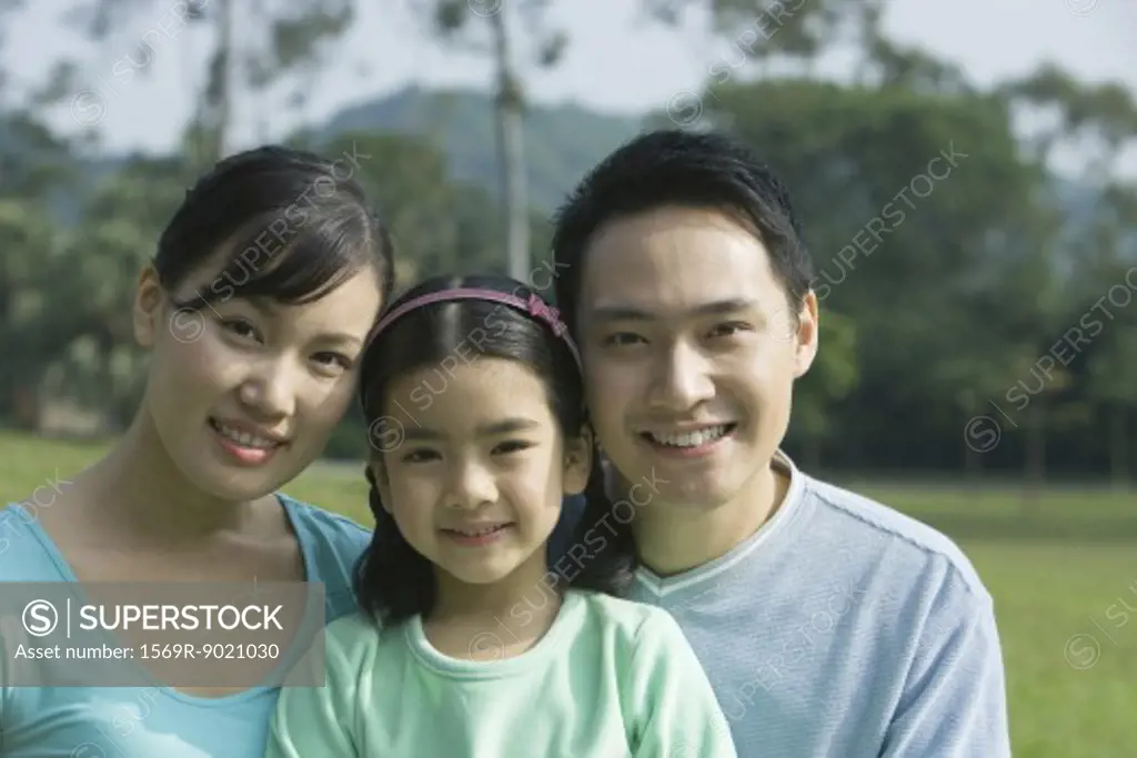 Girl and parents, smiling at camera, portrait