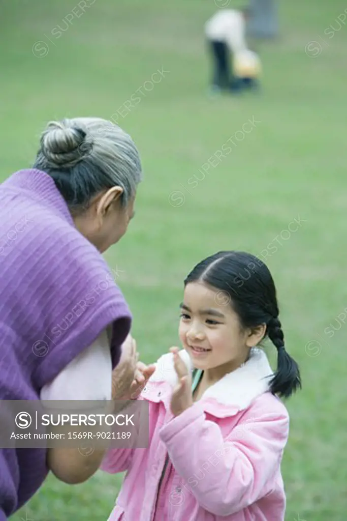 Girl with grandmother, playing clapping game