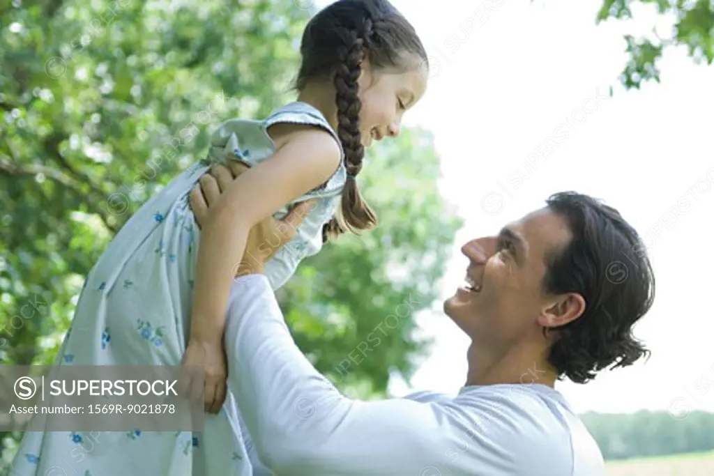 Man holding up daughter in air