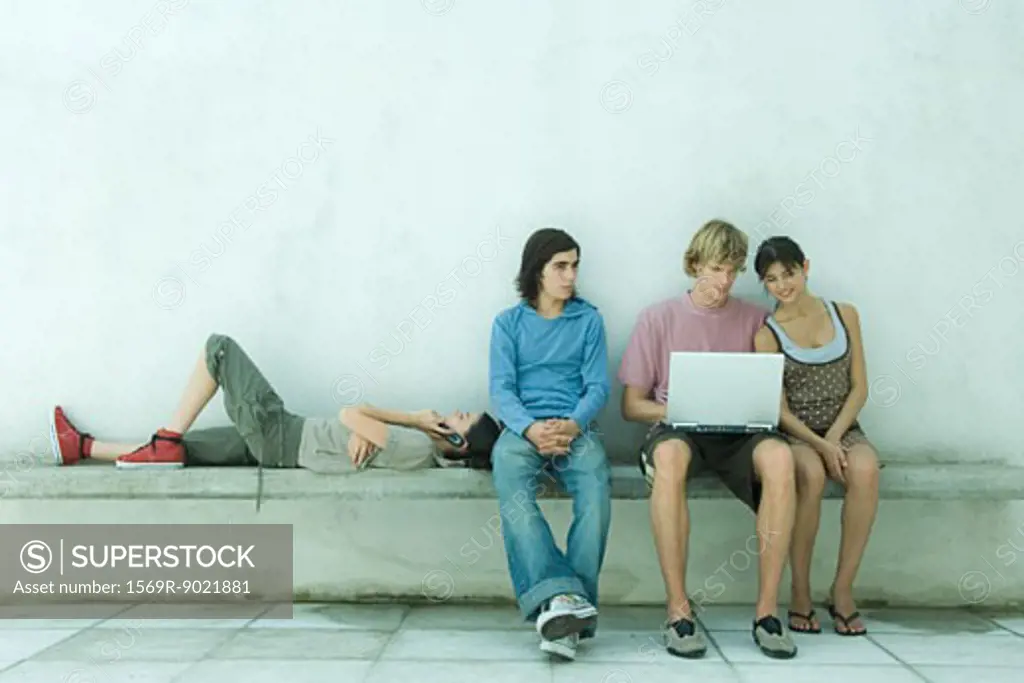 Group of young friends using laptop together