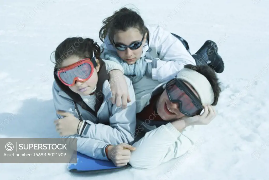 Young skiers lying in snow, portrait