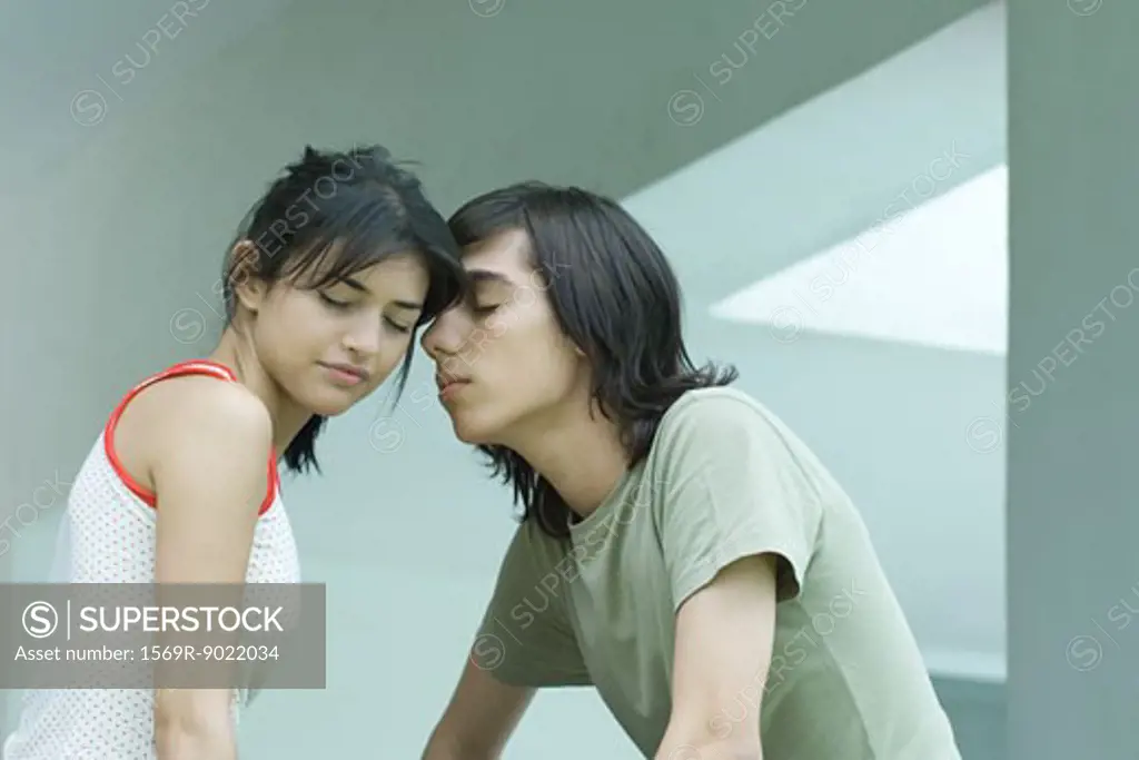 Young couple with heads together, eyes shut
