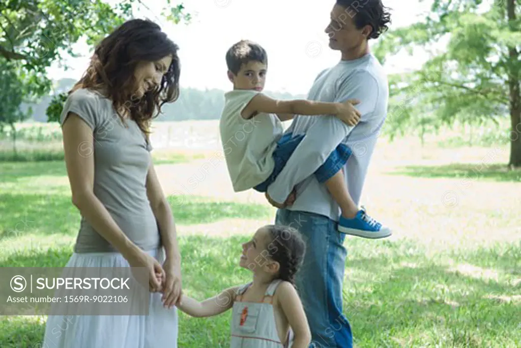 Family outdoors on a grassy lawn on a sunny day