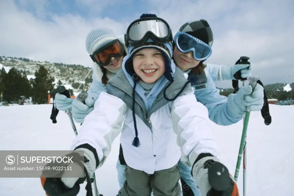 Young skiers standing on ski slope, portrait