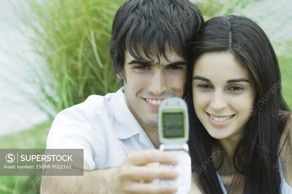 Young couple taking self-portrait with cell phone