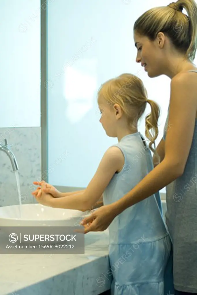 Mother and daughter washing hands together