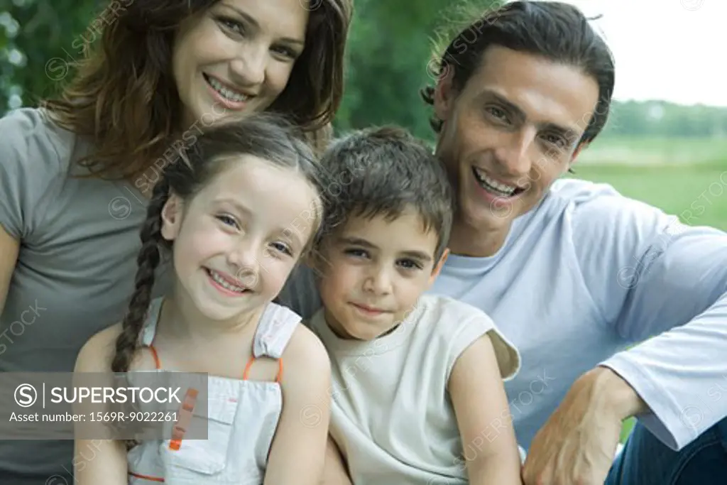 Family outdoors, smiling at camera, portrait