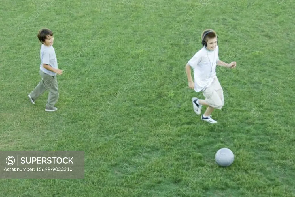 Two boys playing ball on lawn, high angle view