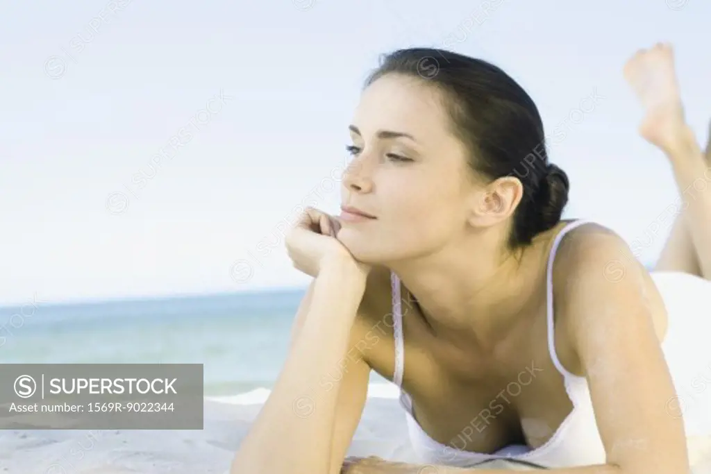 Woman lying on beach, looking away