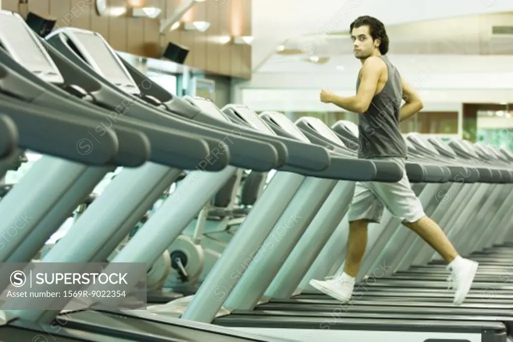 Man running on treadmill in health club