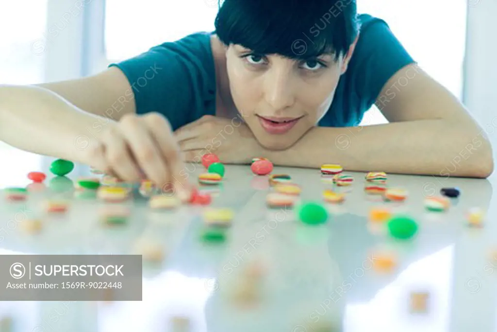 Woman arranging pieces of candy on table