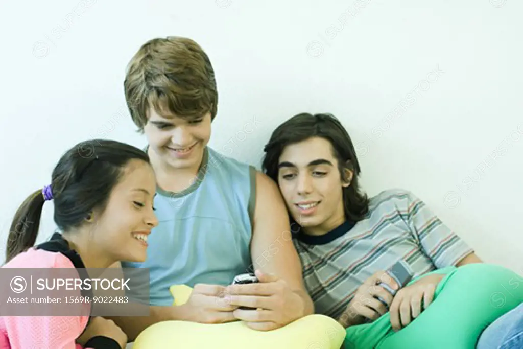 Teenage friends looking at cell phone together