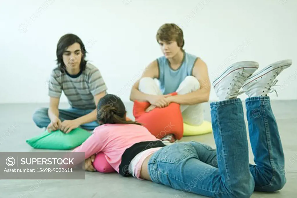 Teenage friends lying on cushions, chatting