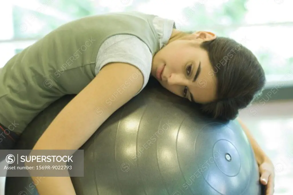 Woman resting on fitness ball